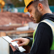 person on job site with tablet application